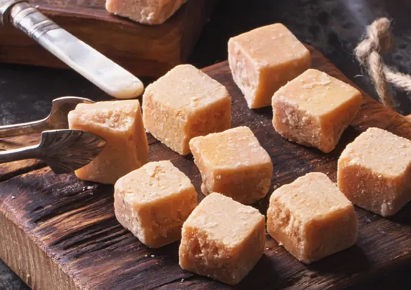 Cubes of homemade fudge on a wooden board
